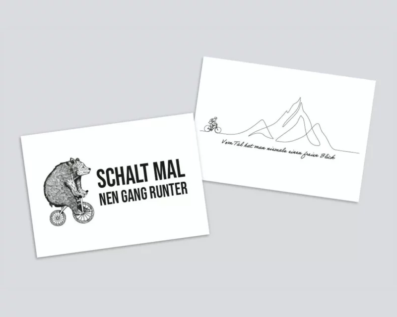 Zwei Postkarten nebeneinadner mit dem Motiven "Bär auf Fahrrad" und "Fahrradfahrer vor Berg"